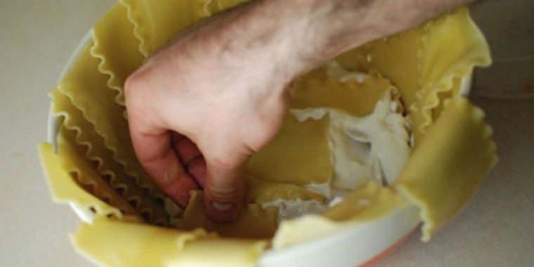 Han lægger lasagneplader i skålen, men vent til den vendes på hovedet