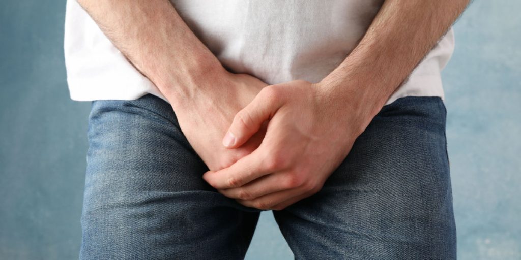 Ung mand mister sin testikel, da han bukker sig ned for at samle en bold op