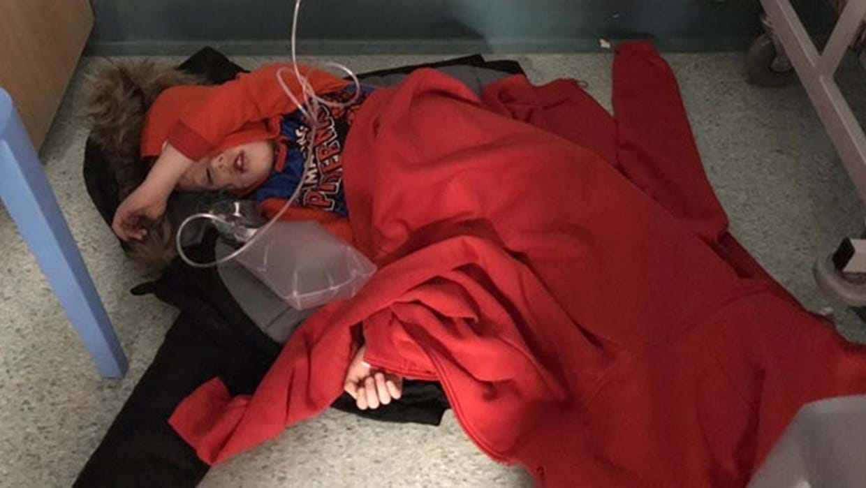 Lille dreng med lungebetændelse tvunget til at sove på hospitalets gulv på grund af mangel på senge